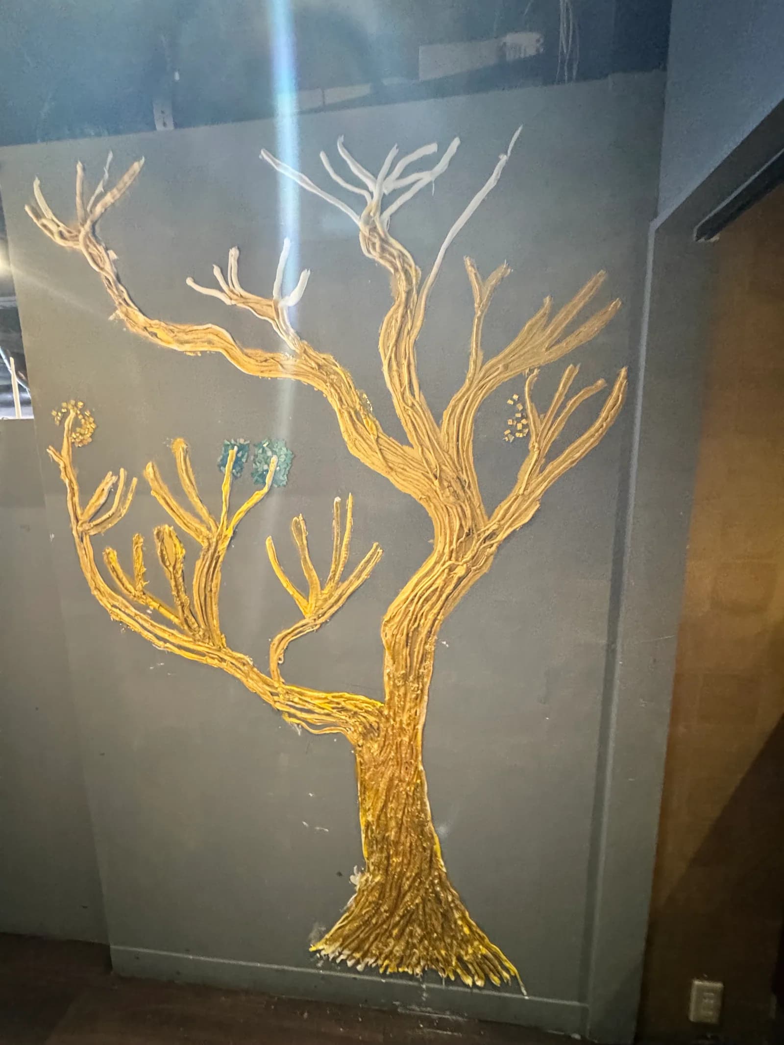 Gold-branch wall art painted on a wall of the Ginza Main Store: a single gilded tree spreading its branches across a dark ground